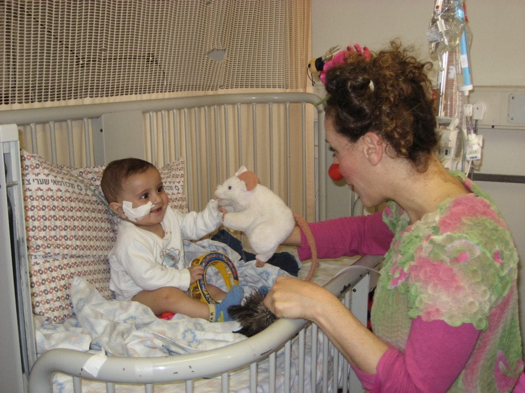 A medical clown brings cheer to a baby in the hospital undergoing medical treatment. (Photo: Dream Doctors)