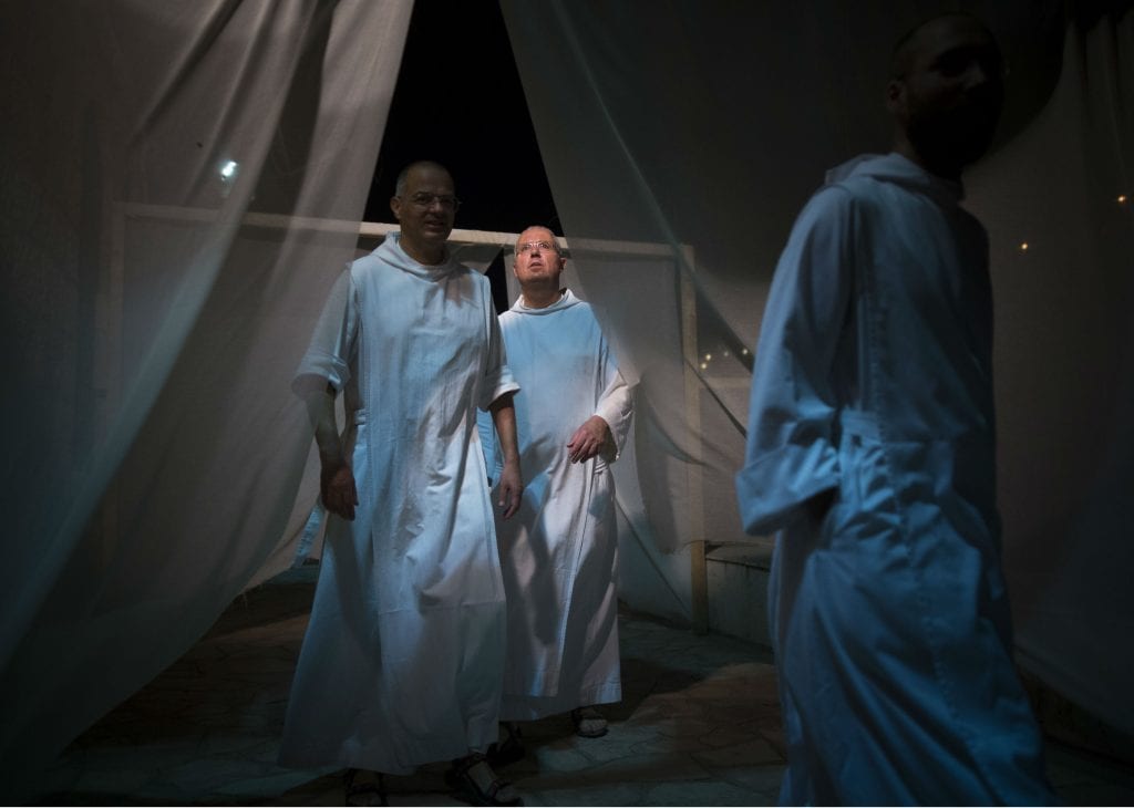 Monks walking through white curtains at the "Amen" event, part of Mekudeshet 2016 festival in Gehinnom, Jerusalem, September 7, 2016. (Yonatan Sindel/Flash90)