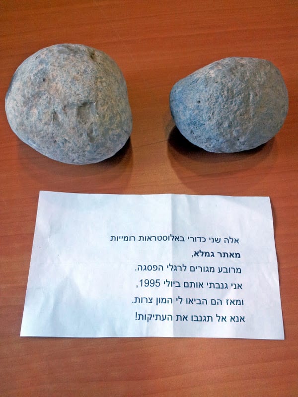 The trebuchet stones and the note accompanying them. (Photo: Dr. Dalia Manor/ Museum of Islamic and Near Eastern Cultures, Be’er Sheva)
