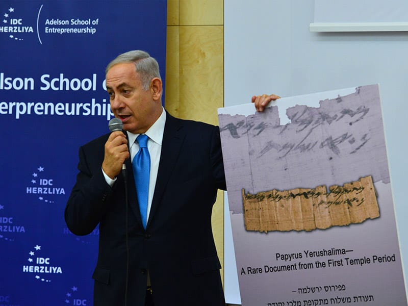 PM Netanyahu holds a close-up view of the papyrus at the dedication of the Adelson School of Entrepreneurship at IDC Herzliya. (GPO/Kobi Gideon)
