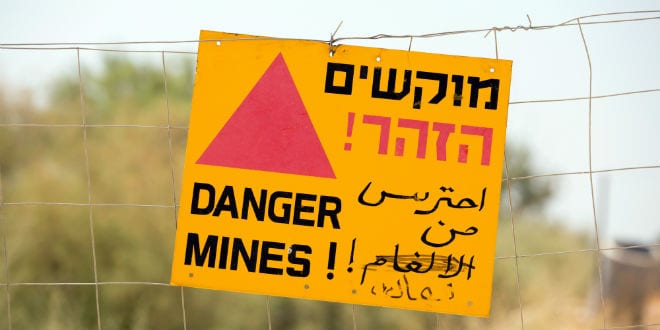 Signs on the fence at Qasr al-Yehud warn visitors of mines in the area. (Photo: Shutterstock.com)