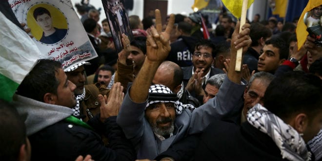 A Palestinian man celebrates at the welcome reception for released Palestinian prisoners at the Muqataa presidential ground in Ramallah, in the early hours of Tuesday, December 31, 2013. This was the third stage of a deal to incrementally release a total of 104 Palestinian prisoners, brokered by the United States in July that brought a resumption of peace talks. (Photo: Hadas Parush/Flash90)