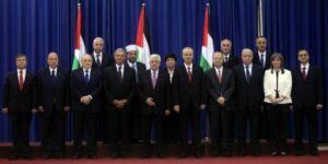Palestinian unity government members including President Mahmoud Abbas (C), and Prime Minister Rami Hamdallah (5R), pose for a photo during during the swearing in ceremony of the government at the Palestinian Authority's headquarters in the West Bank town of Ramallah, on June 02, 2014. The government of national unity headed by Prime Minister Rami Hamdallah was sworn in by President Mahmoud Abbas and for the first time in seven years, the Palestinians have one government in charge of both the West Bank and the Gaza Strip. (Photo: Issam RImawi/FLASH90)