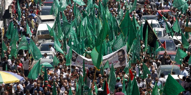 alestinian mourners wave the green flag of the Islamist movement Hamas as they attend the funeral of two Hamas members, Adel and Imad Awadallah, killed by Israeli forces in 1998, after Israel returned the remains of Palestinian militants to their families for burial, on April 30, 2014, in the West Bank city of Ramallah. Adel Awadallah was a senior leader of Hamas' military wing, Ezzeldin al-Qassam Brigades. (Photo: Issam Rimawi/FLASH90)