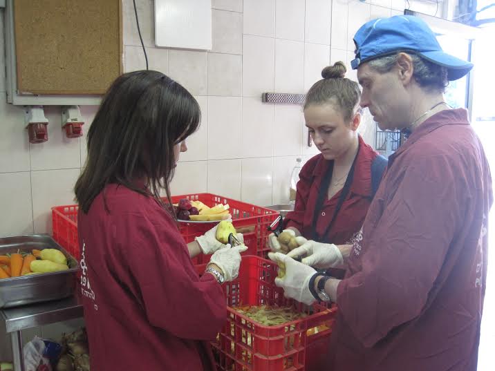 Peeling vegetables for the lunch meal. (Photo: Breaking Israel News)