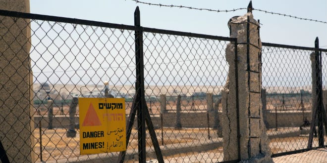 Signs on the fence at Qasr al-Yehud warn visitors of mines in the area. (Photo: Shutterstock.com)