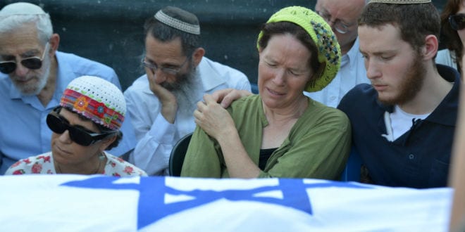 Mother of Naftali Frenkel, Rachel Frenkel, seen crying over the body of her son, during the joint funeral for the three murdered Jewish teens, in the Modiin cemetery, on July 1, 2014. The bodies of Eyal Yifrach, Gilad Sha'ar and Naftali Fraenkel were discovered the previous day in a field near Karmei Tzur in the West Bank. The three teenagers had been missing since June 12, while hitchhiking in the West Bank, and were presumed to have been abducted by terrorists. (Photo: Flash90)