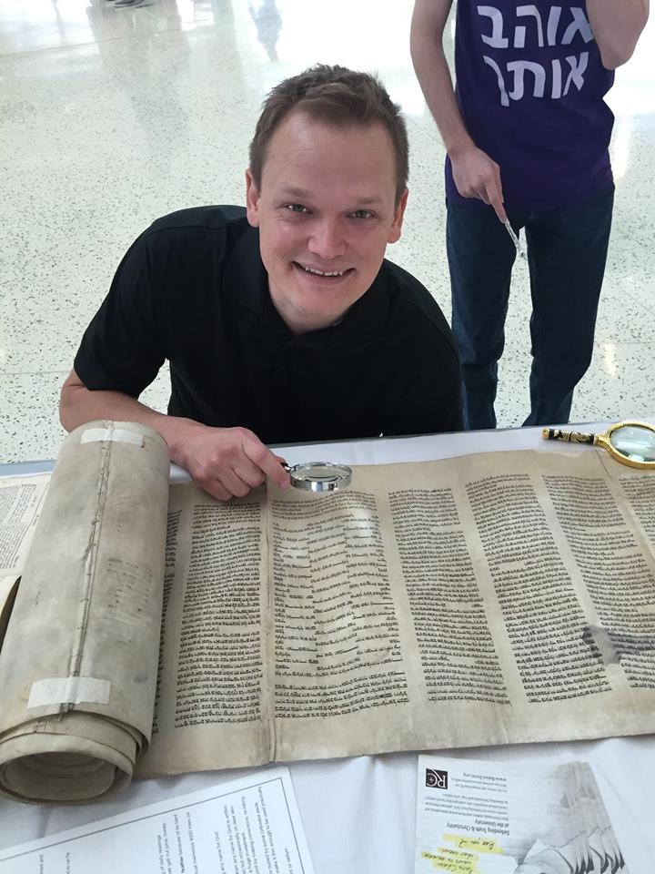 A student examines the Torah scroll (Ratio Christi Facebook Page)