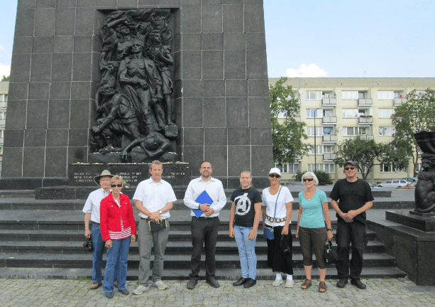 Rabbi Tuly Weisz with the Israel365 group in front of the Warsaw Ghetto Uprising monument. (Photo: Breaking Israel News)